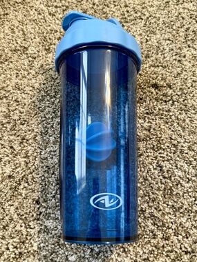 Large blue plastic protein drink shaker 24 oz with flip top lid finger grip gym